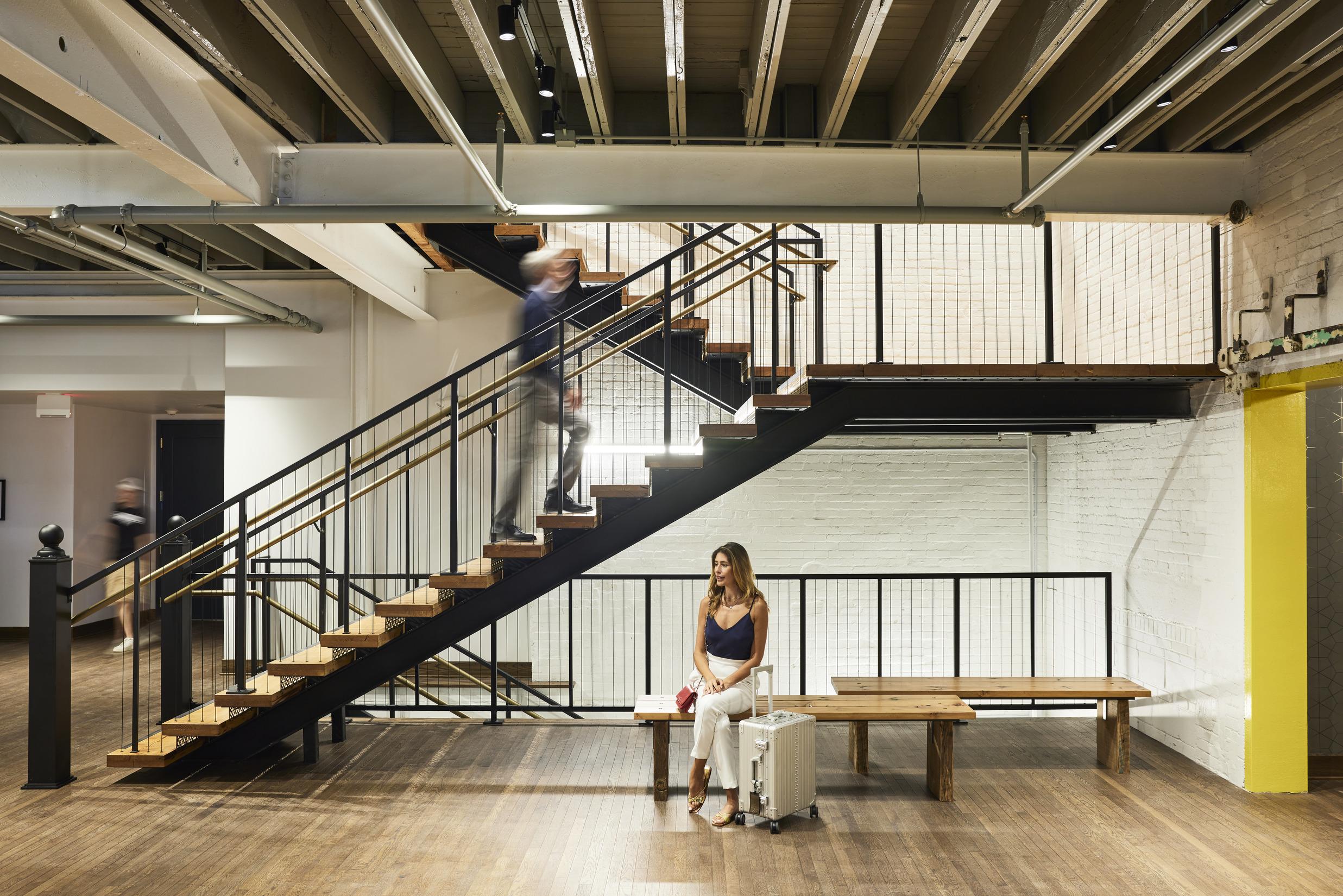 Man ascending staircase; women sitting on chaise
