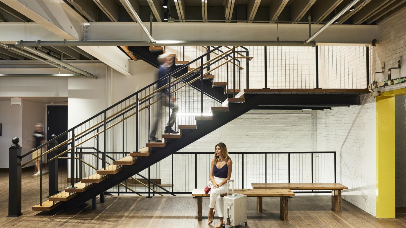 Man ascending staircase; women sitting on chaise